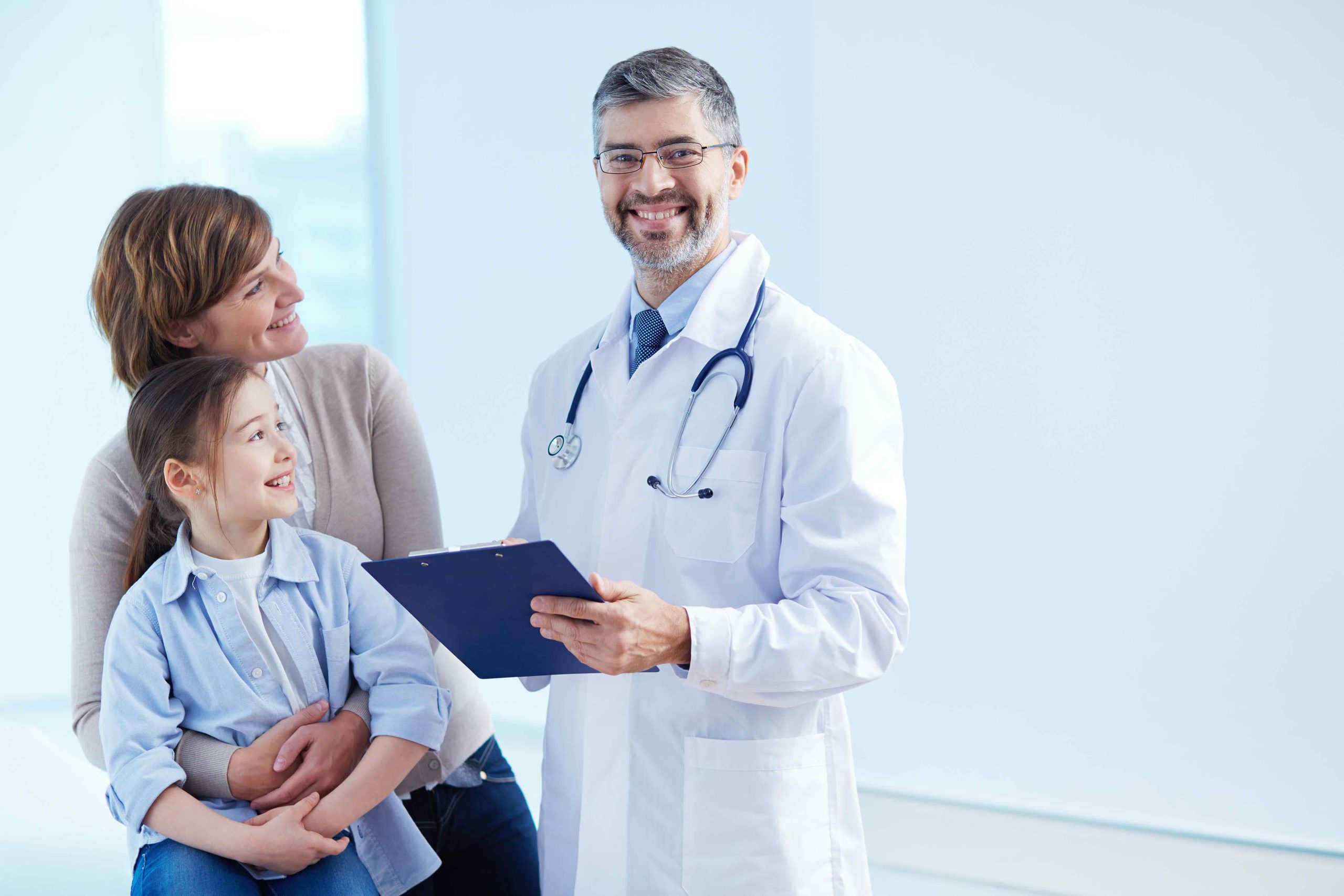 Cute girl and her mother looking at the doctor in hospital